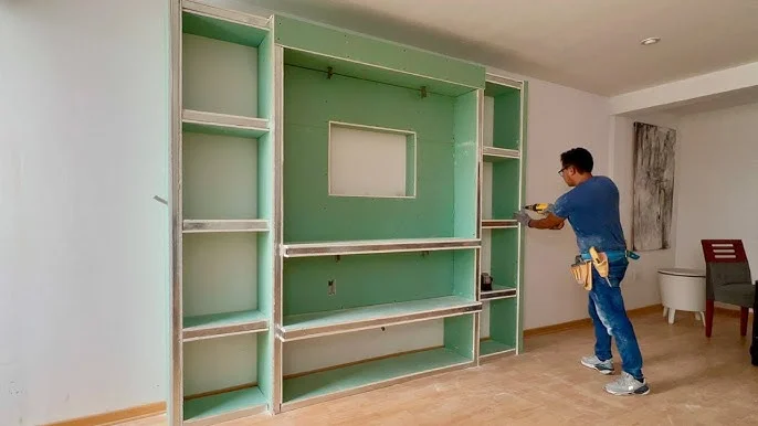 Fotografía de un hombre construyendo estanterías en el interior de una vivienda con el sistema Drywall